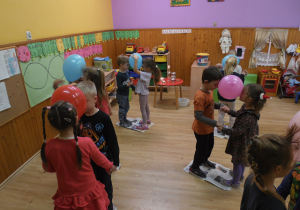 Krasnoludki tańczą w parach z balonami.