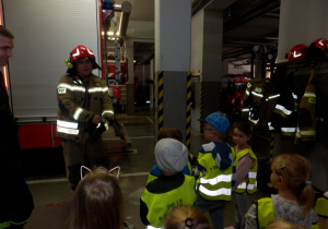 Dzieci oglądają ubranie strażaków potrzebne w akcji.